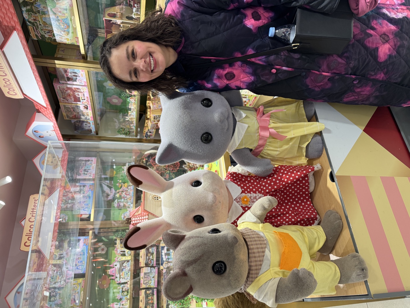 Tess smiling next to giant Calico Critters figures at FAO Schwarz